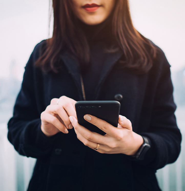 Woman in jacket looking at mobile phone
