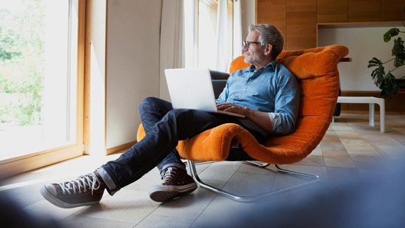 Man sitting in chair with laptop